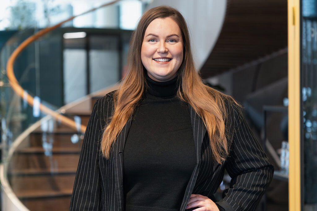 Laura Nykänen is posing in front of stairs.