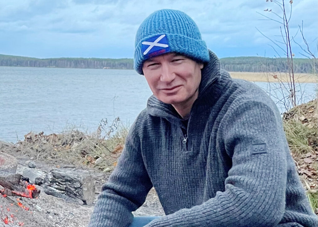 Patrick is posing by the lake.