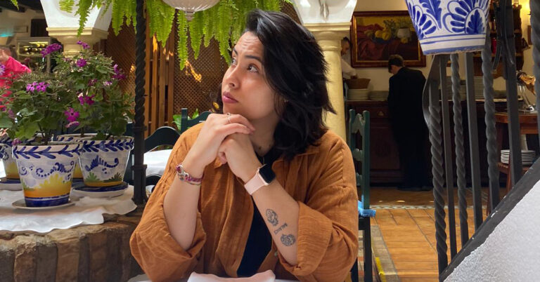 Priscilla is sitting in a restaurant.