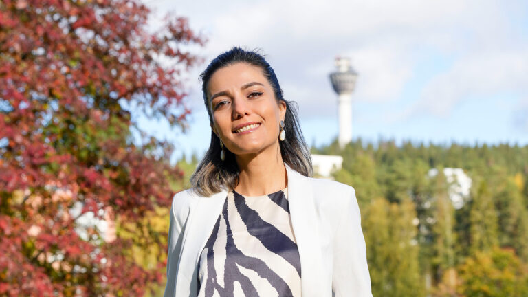 Parastoo is standinf in front of Puijo tower in Kuopio.